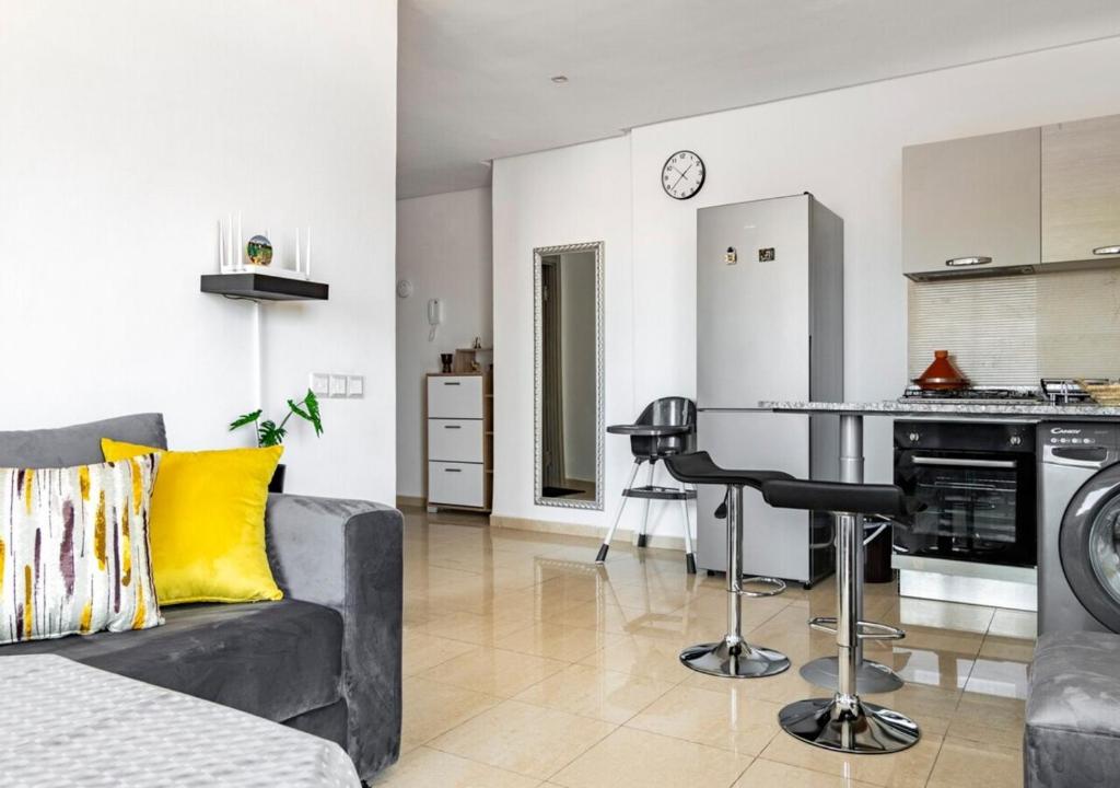 a living room with a couch and a table at Splendide Appartement avec Piscine à Agadir in Agadir