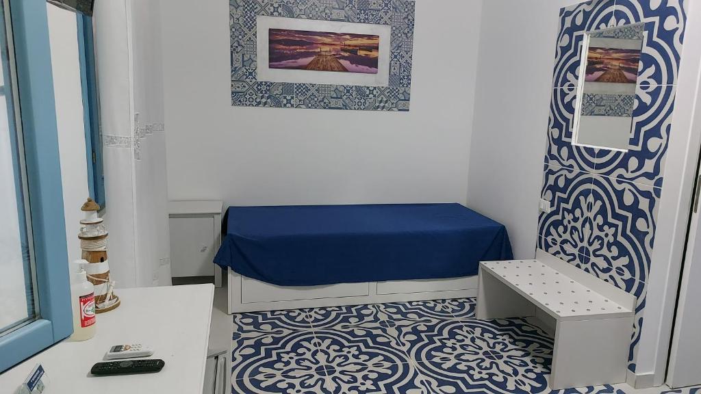 a small room with a bed and a blue and white floor at Benvenuti al Sud B&B in Macari