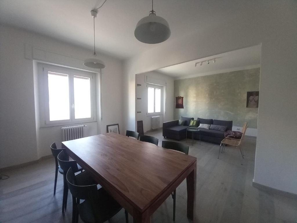 een woonkamer met een houten tafel en een bank bij Appartamento di charme a Polverigi, Marche in Polverigi