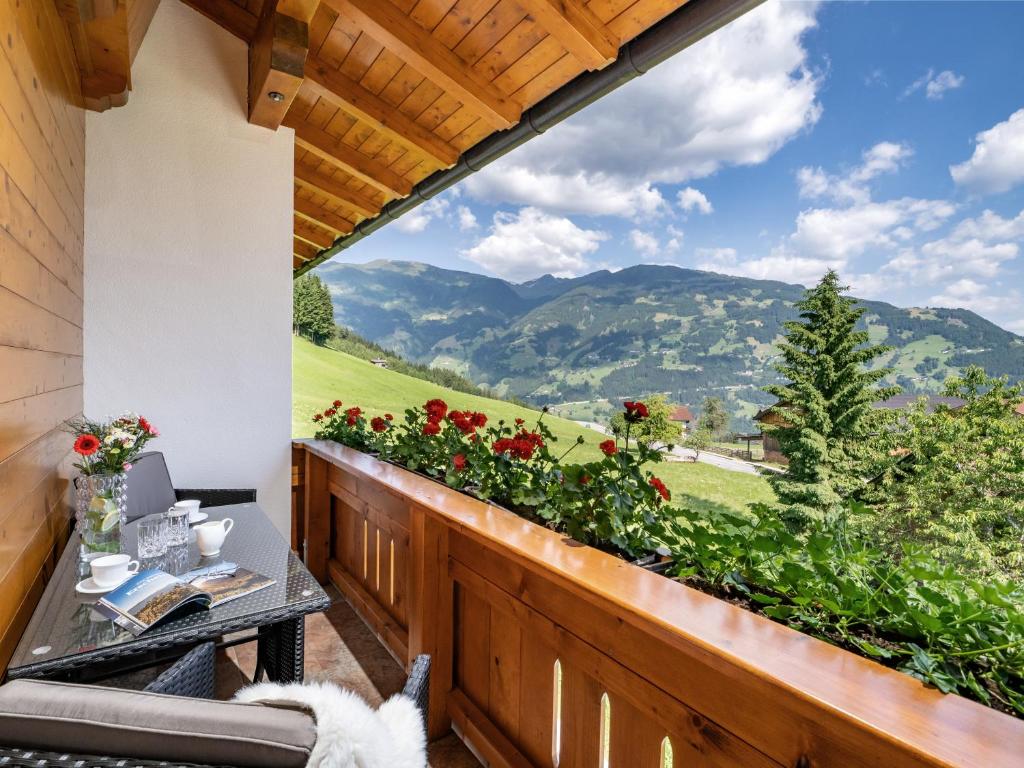 a balcony with a table and a view of mountains at Apart Magdalena in Hainzenberg