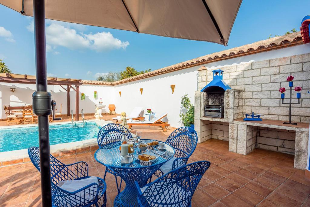 Peñaflorにある3 bedrooms villa with private pool enclosed garden and wifi at Penaflorのパティオ(テーブル、椅子付)、プールが備わります。