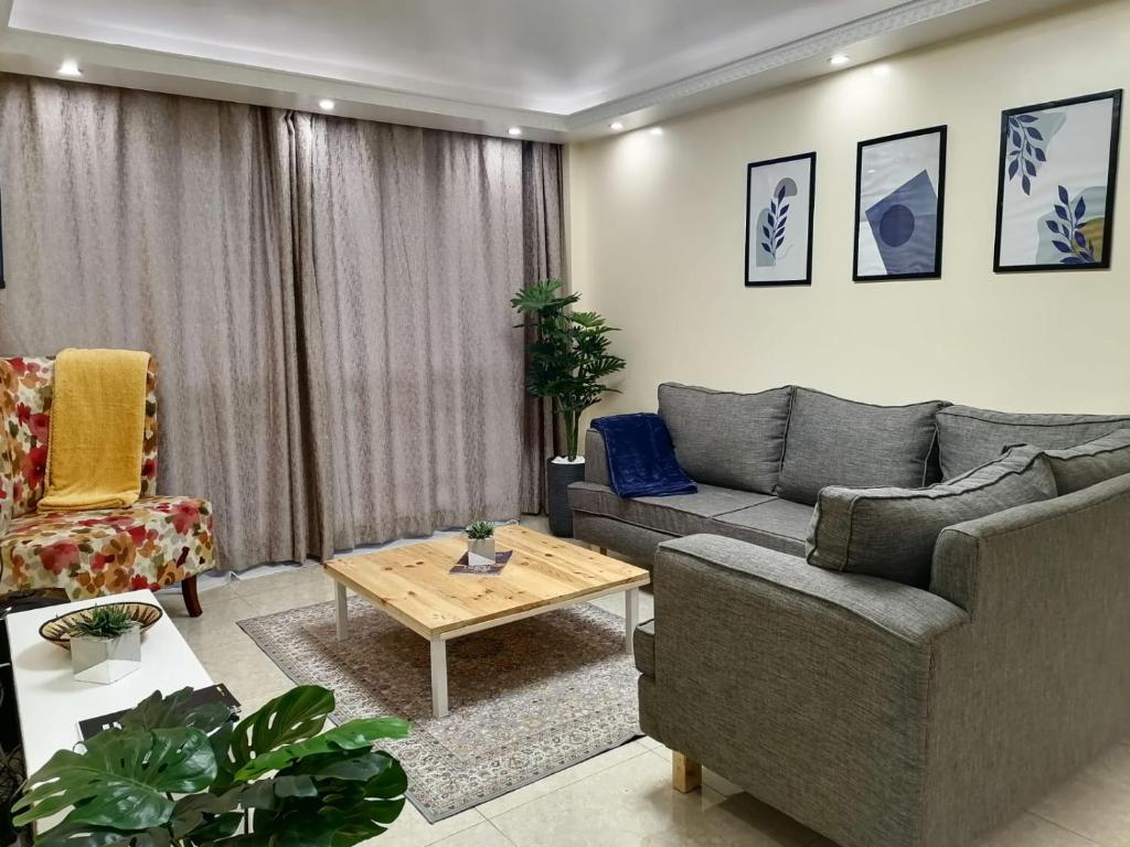 un soggiorno con divano e tavolo di Serene apartment in the suburbs a Nairobi