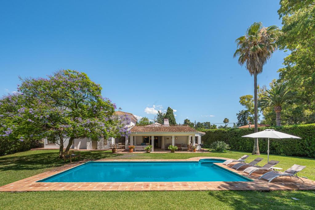 a swimming pool in front of a house at Villa amplia con piscina privada ideal familias y grupos in Estepona