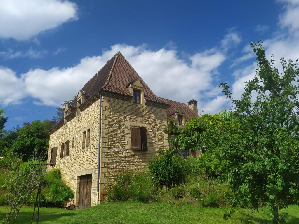 un antiguo edificio de ladrillo con techo en un campo en Gite 6 personnes Sarlat/Rocamadour, en CazoulÃ¨s