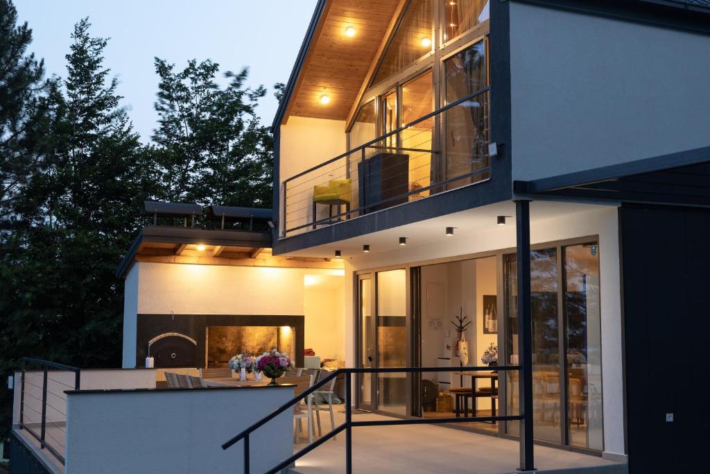 a house with a balcony with a view of the backyard at Copanjek Country House in Plešivica