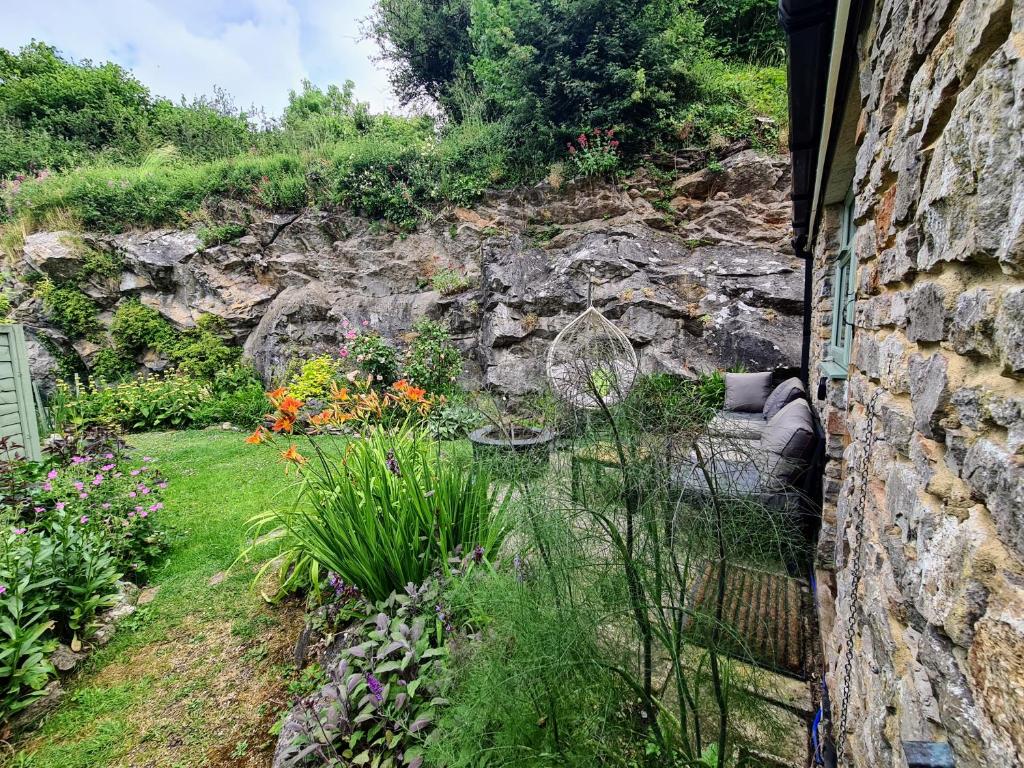 ラドストックにあるPRIVACY Entire BARN for 4 Garden Cliff Vobster Quay Frome Longleat Bath Stonehenge BBQ HQ & Pet FREE-ndlyの花の庭と石壁
