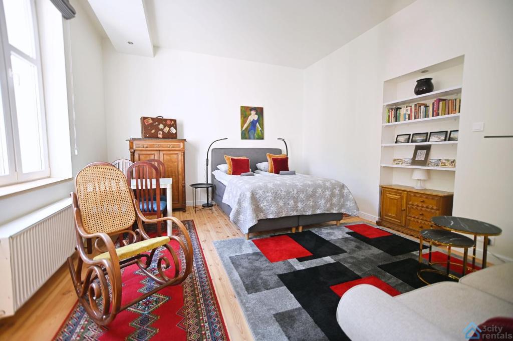 een slaapkamer met een bed, een bank en een tapijt bij Travel by 3City Rentals in Sopot