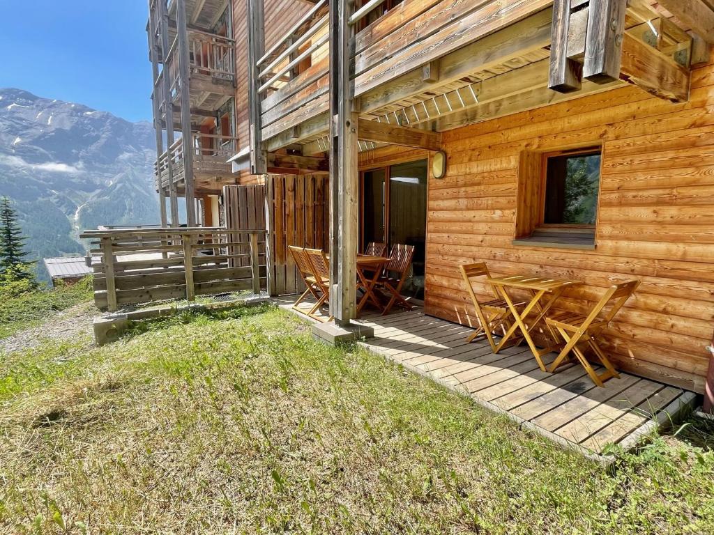 une cabane en bois avec une table et des chaises sur la terrasse couverte dans l'établissement Appart 250m des pistes et parking couvert privatif, à Orcières