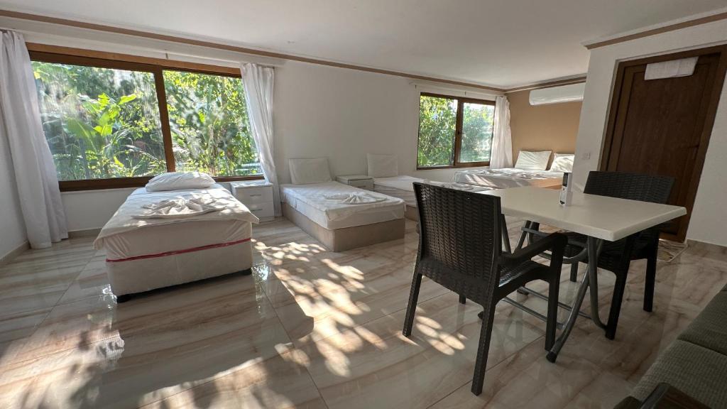 a bedroom with a bed and a table and chairs at Kiriş Banana Suit in Kemer