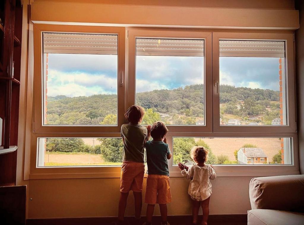サリアにあるLópez Estaciónの窓から3人の子供が見ている