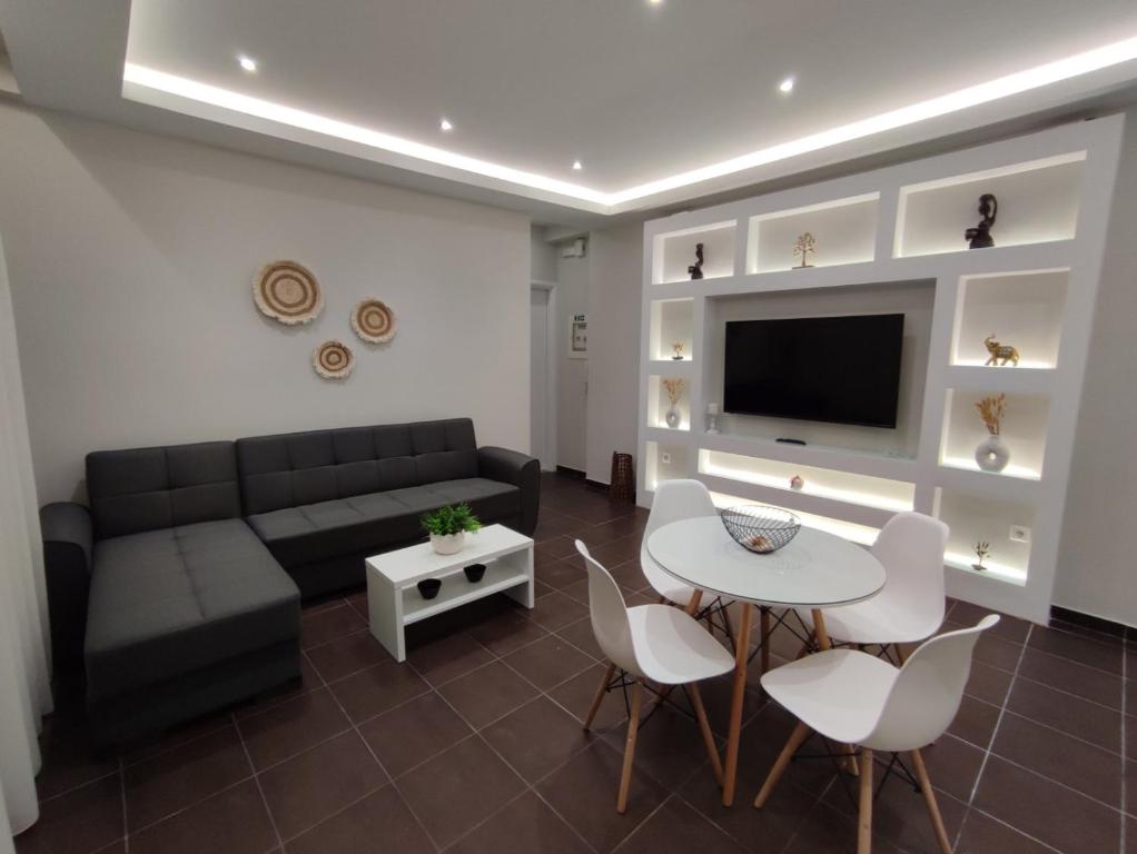 een woonkamer met een bank, een tafel en stoelen bij Lydia Apartment in Vonitsa