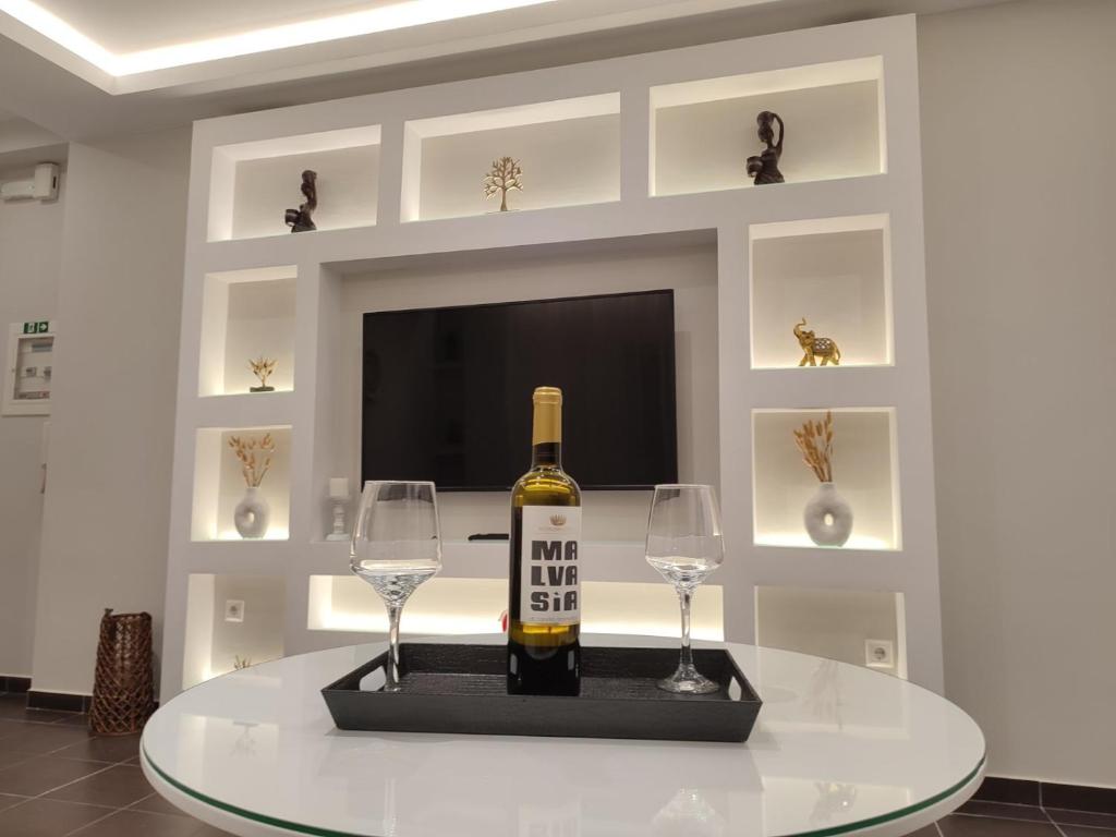 a bottle of wine on a table with two wine glasses at Lydia Apartment in Vonitsa