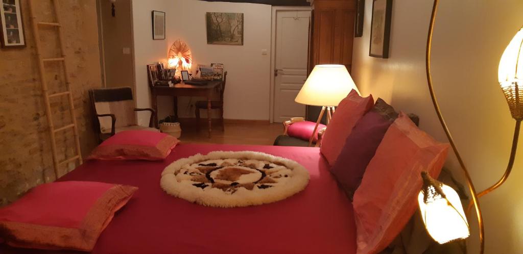 a bedroom with a red bed with aulture on it at Bell'Accueil Chambres d'Hôtes Cluny in Cluny