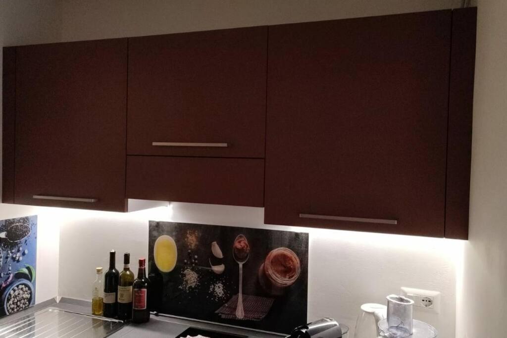 a kitchen with brown cabinets and bottles of wine at Giappetto House in Limone Piemonte