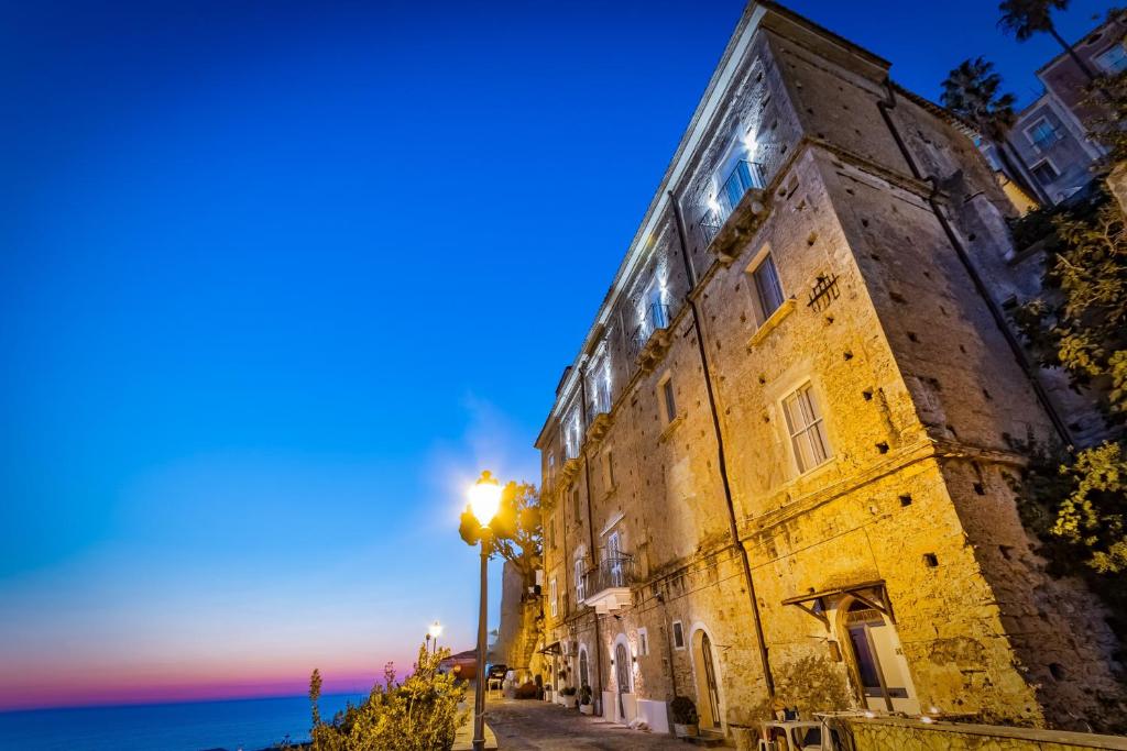 an old building next to the ocean at night at Al Duomo B&B in Amantea