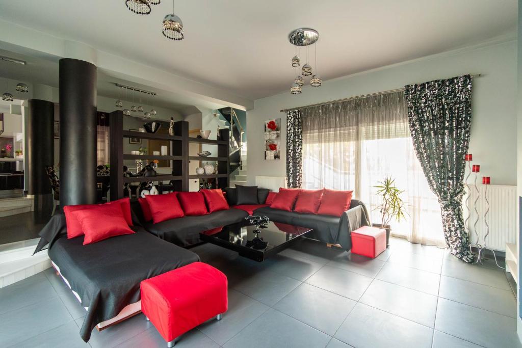 sala de estar con sofá negro y almohadas rojas en BLACK & WHITE CITY VILLA, en Alexandroupoli
