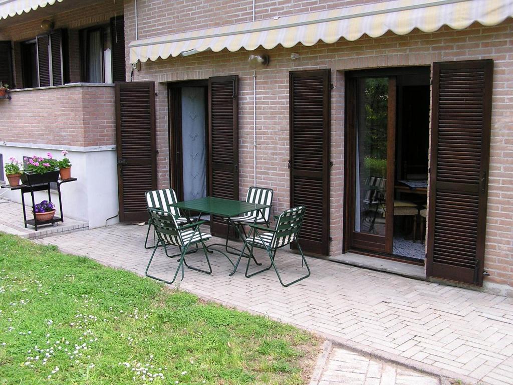 eine Terrasse mit einem Tisch und Stühlen neben einem Gebäude in der Unterkunft Apartment Maria & Patrizio in Lignano Sabbiadoro