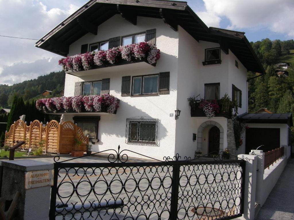 a white house with flowers on the side of it at Haus Kröll in Mittersill