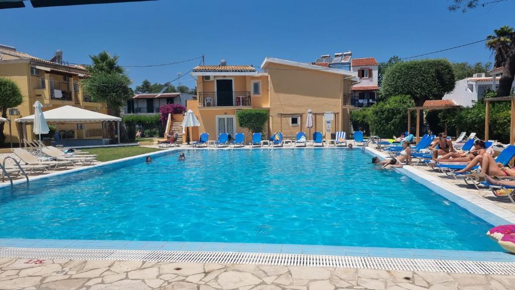 una piscina en un complejo con gente sentada en sillas en Meraki Kavos en Kávos