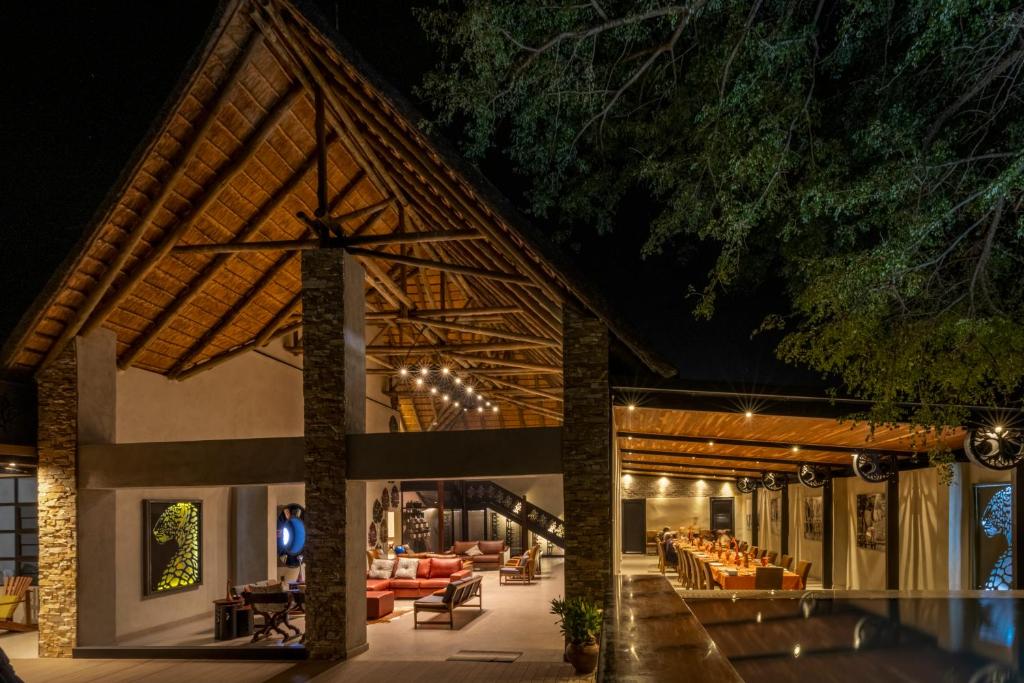 Chobe River Lodge في كاسان: لوبي المنتجع مع كنب وطاولات في الليل