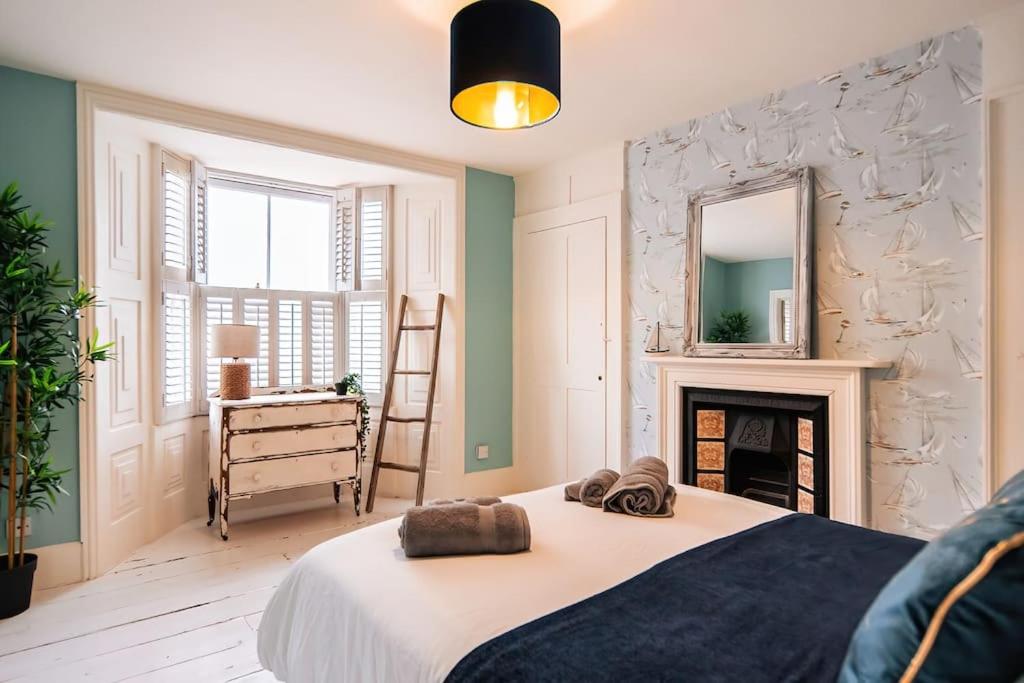 a bedroom with a bed with a fireplace and a mirror at Seaside Bliss: Period Home, Games Room, Pool Table & Hot Tub in Margate