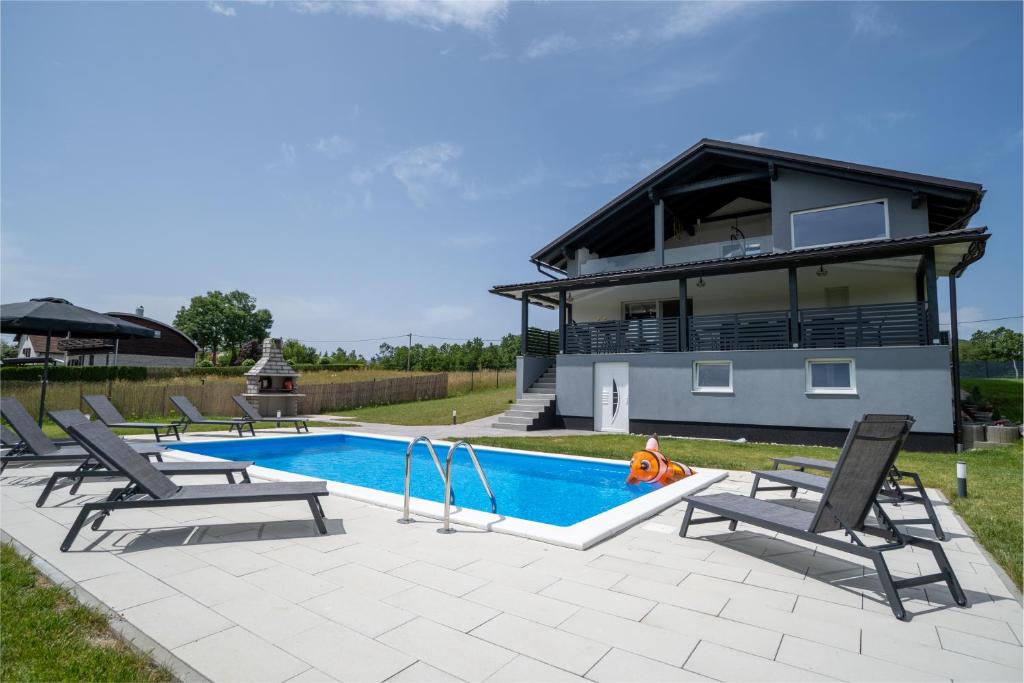a villa with a swimming pool and a house at Plum house - villa with pool in Gospić