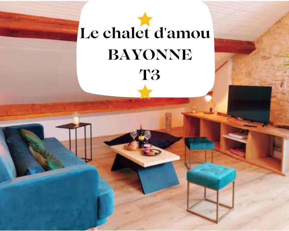 een woonkamer met een blauwe bank en een tafel bij Le Chalet d'Amou in Bayonne