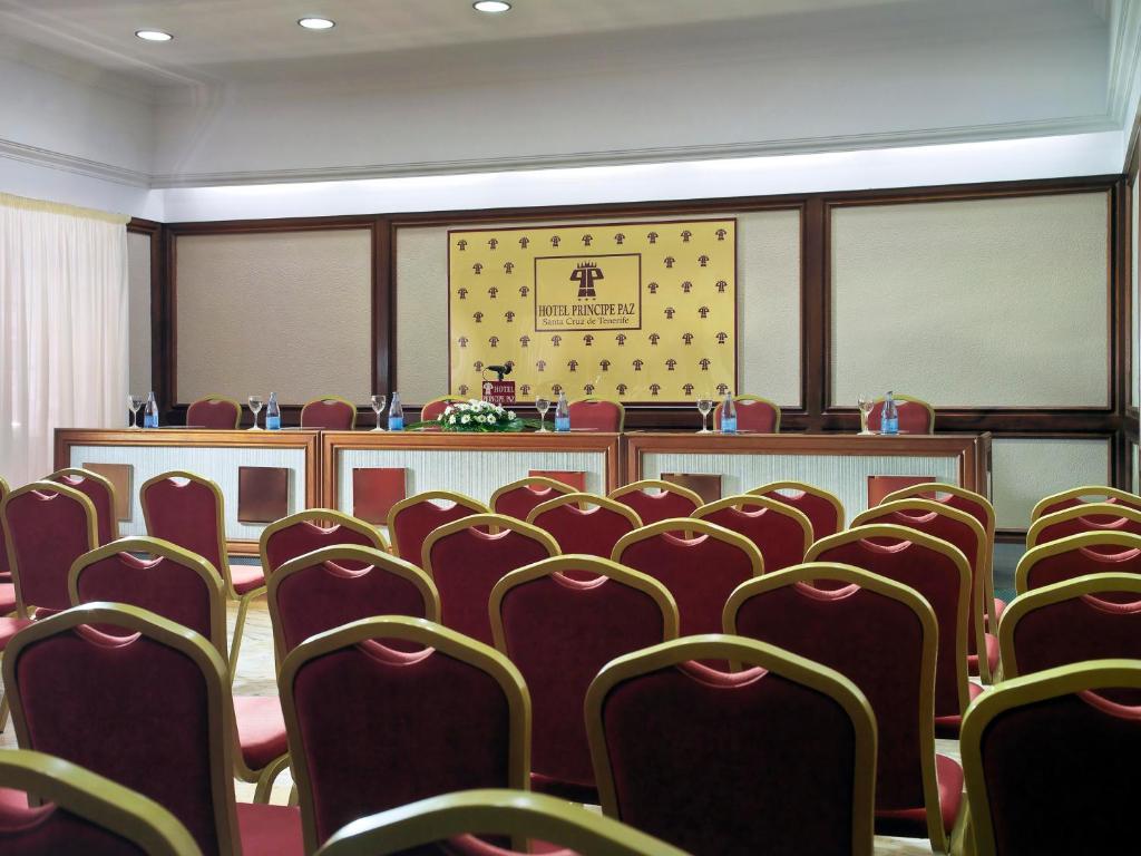 an empty conference room with red chairs and a podium at Hotel Principe Paz in Santa Cruz de Tenerife