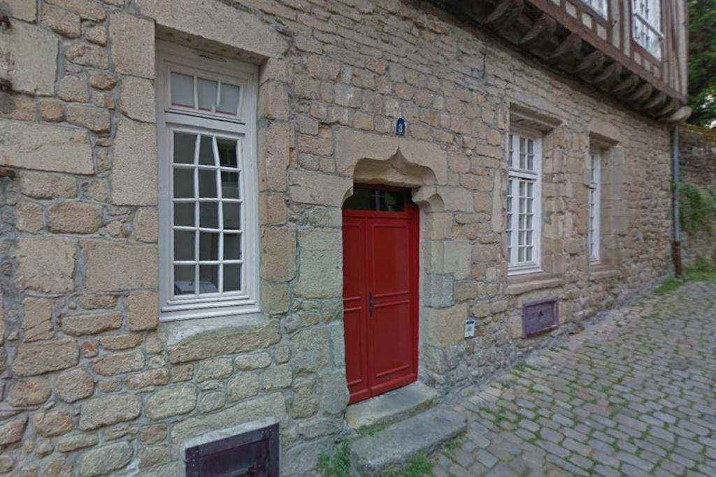 a red door on the side of a stone building at Studio Design Sous Toits IntraMuros Vue Cathédrale in Vannes