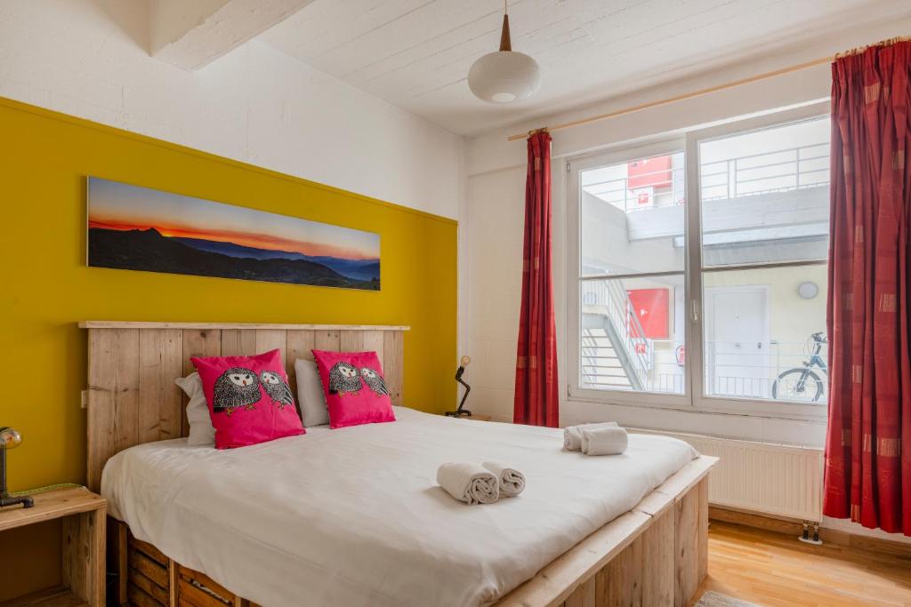 ブリュッセルにあるDupre Cosy Residenceのベッドルーム1室(ピンクの枕が付いた大型ベッド1台付)