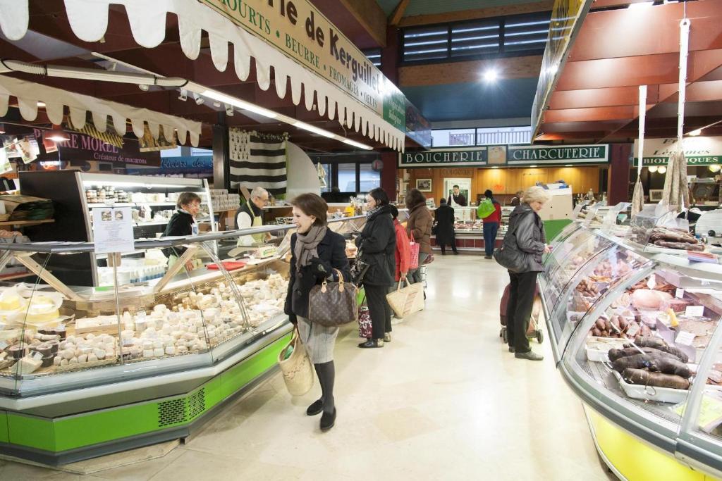 a group of people walking through a grocery store at Studio Design Sous Toits IntraMuros Vue Cathédrale in Vannes