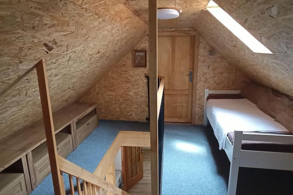NetoliceSunny House的一间阁楼间,设有床铺和楼梯