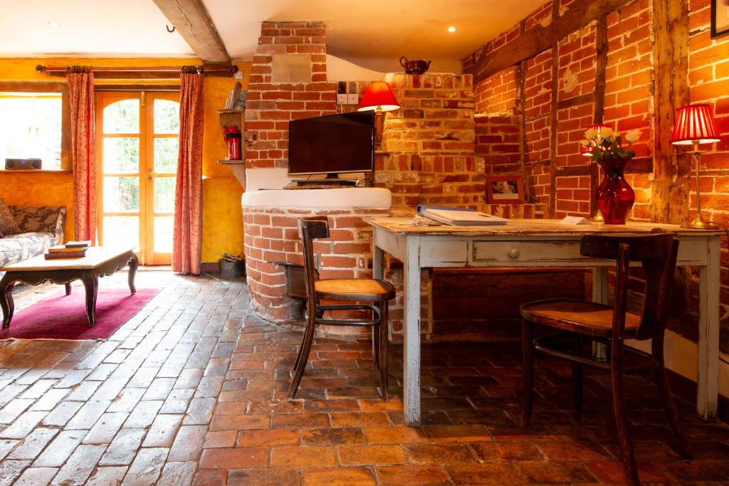 a room with a desk and a tv on a brick wall at The Bakery a honeymooners favourite cosy stylish with lovely walks and pubs 