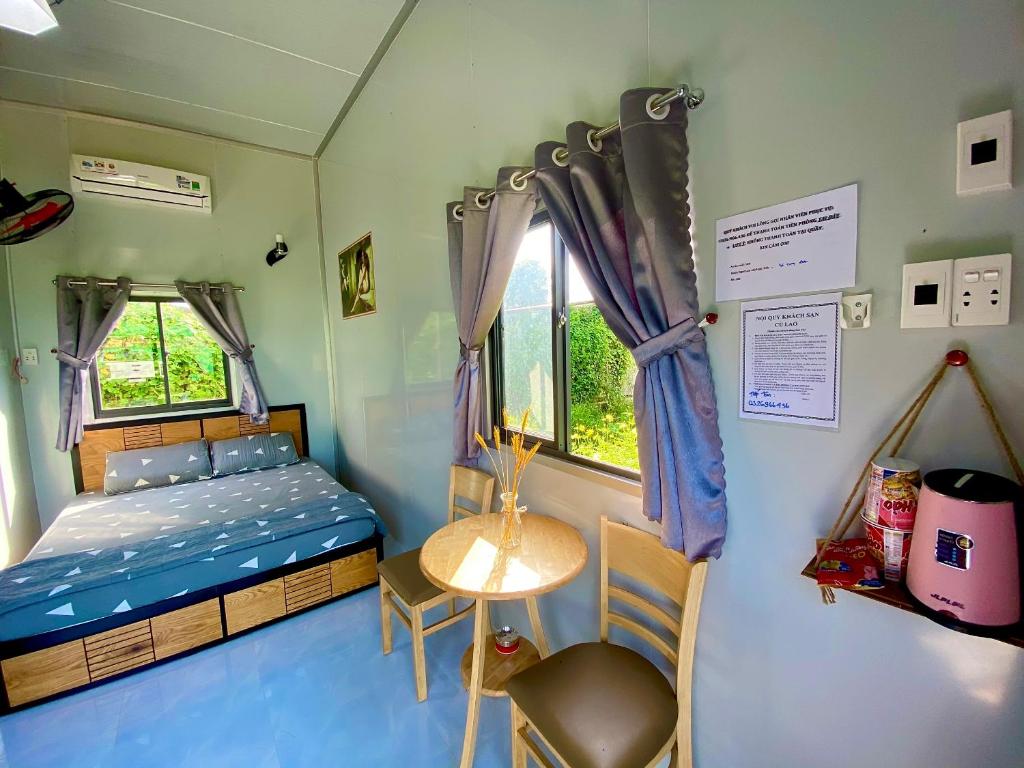 Habitación pequeña con cama, mesa y ventana en Hotel Cù Lao 1, en Ấp Thanh Sơn (1)