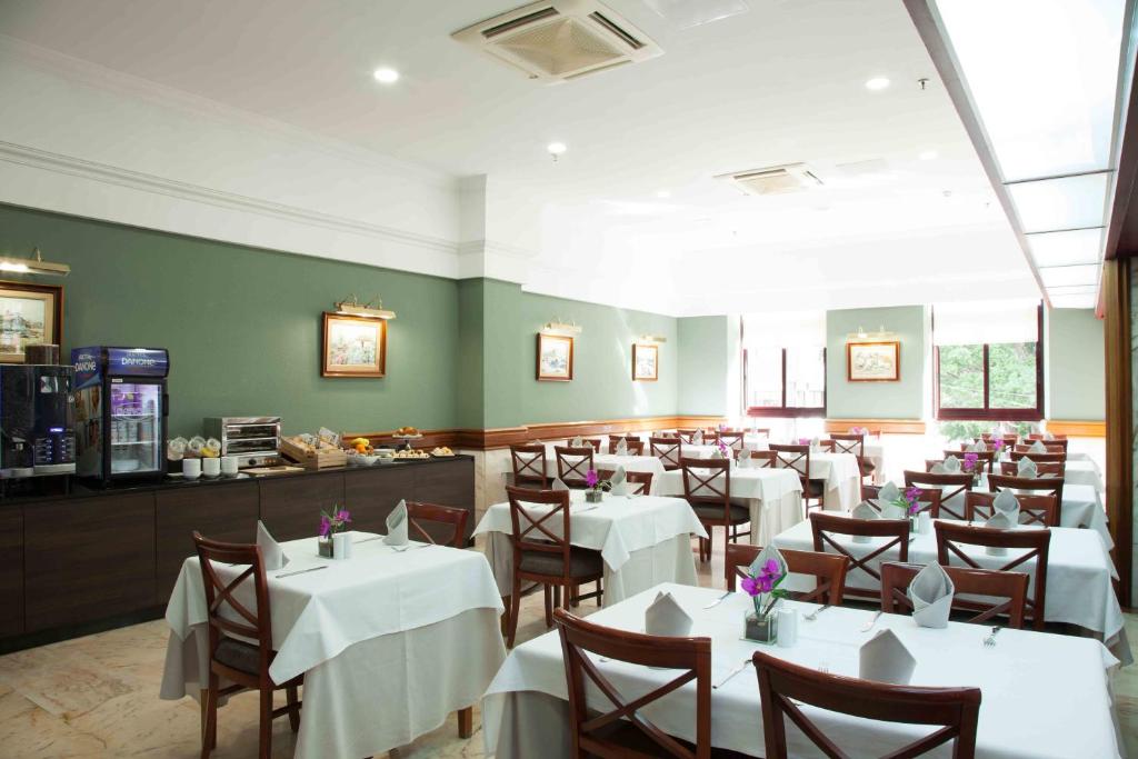 a restaurant with white tables and chairs and a counter at Hotel Principe Paz in Santa Cruz de Tenerife