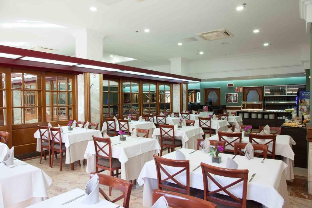 a dining room with white tables and chairs at Hotel Principe Paz in Santa Cruz de Tenerife