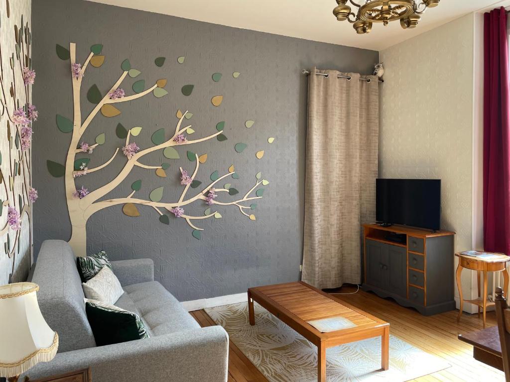 - un salon orné d'une fresque murale représentant les arbres dans l'établissement L Ensorcel Mans, séjour magique en coeur de ville, au Mans