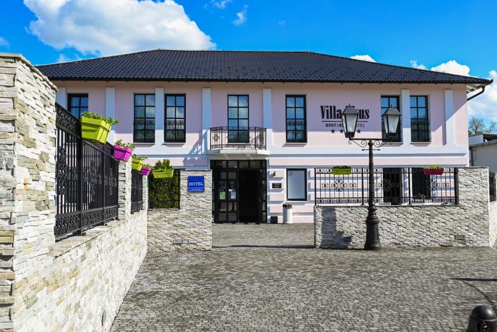 un grand bâtiment blanc avec une porte noire dans l'établissement Boutique Hotel Ukus, à Tešanj