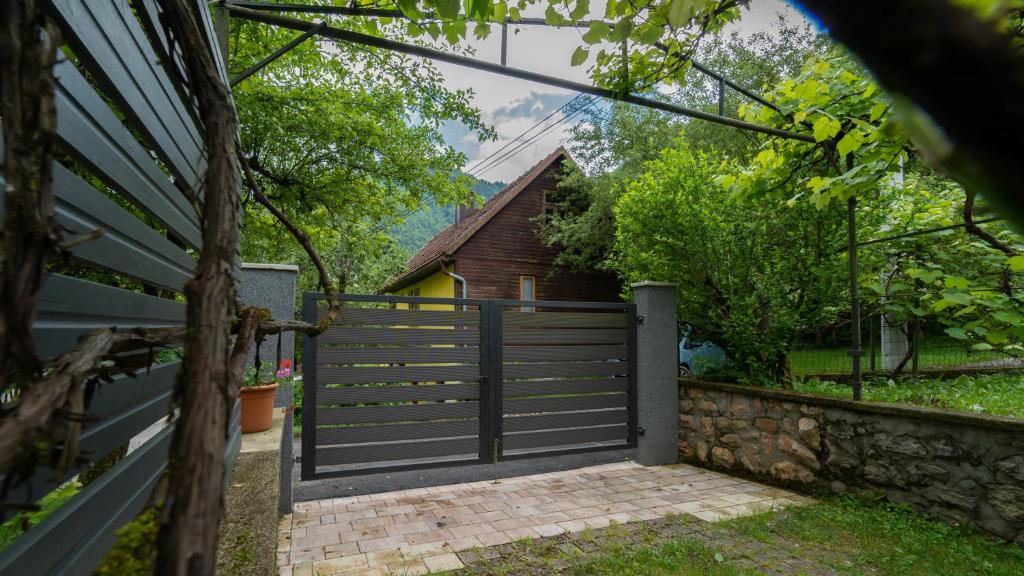 a gate to a backyard with a house at Holiday house Kajfes in Brod na Kupi