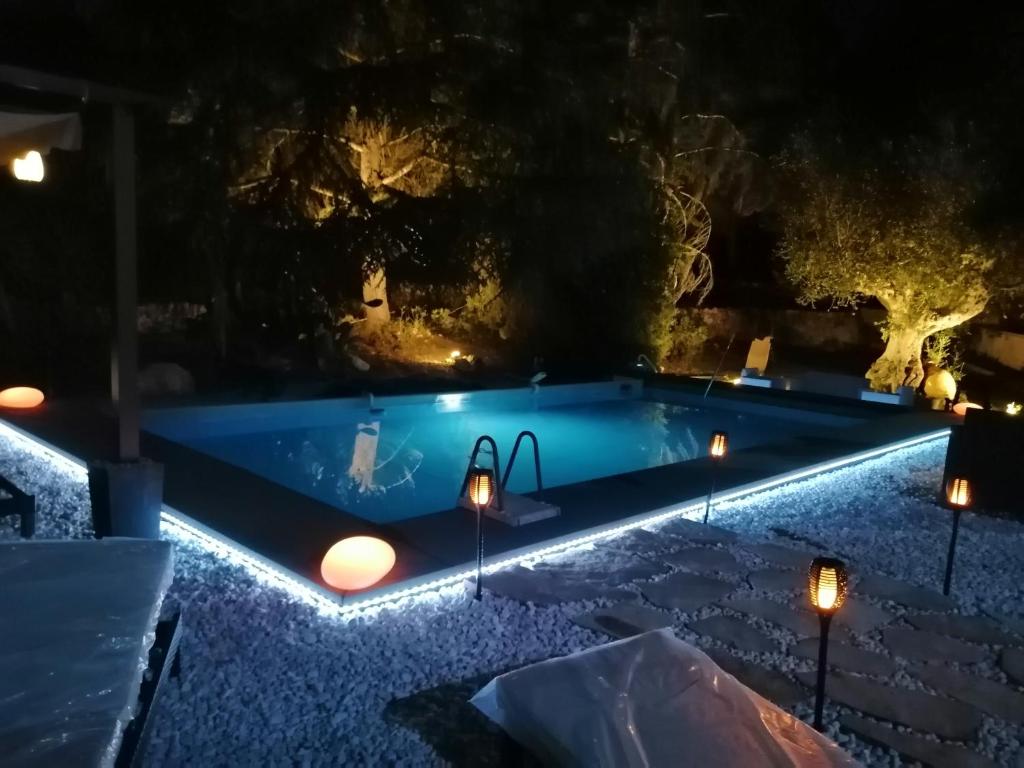 una piscina notturna con luci di All'Ombra della Pineta a Ostuni