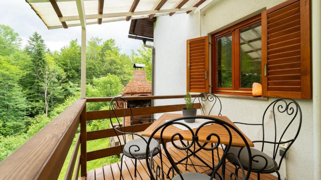 a wooden balcony with a table and chairs on it at Holiday house Kajfes in Brod na Kupi