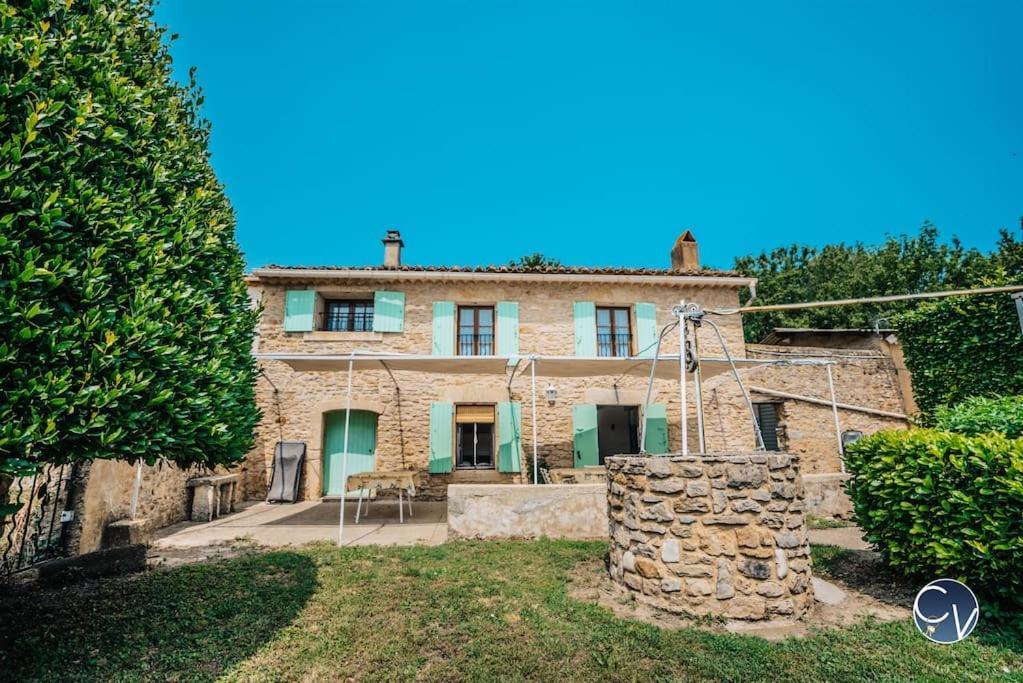 una antigua casa de piedra con una pared de piedra en Petit Mas au calme proche centre, en Bagnols-sur-Cèze