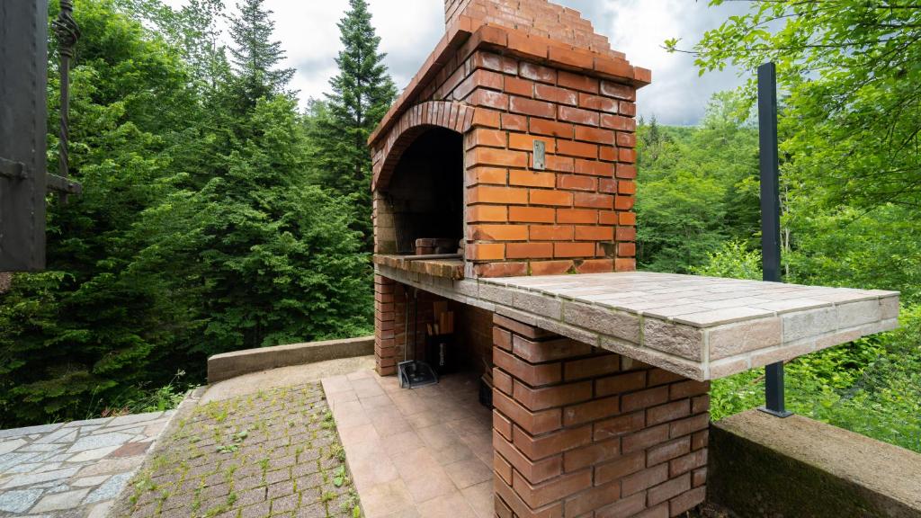 an outdoor brick oven with a stone patio at Holiday house Kajfes in Brod na Kupi