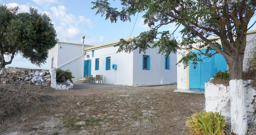 Livadi的住宿－Αρχοντικό ΑΤΤΙΚ - ATTIK MANSION，白色的建筑,有蓝色的门和树