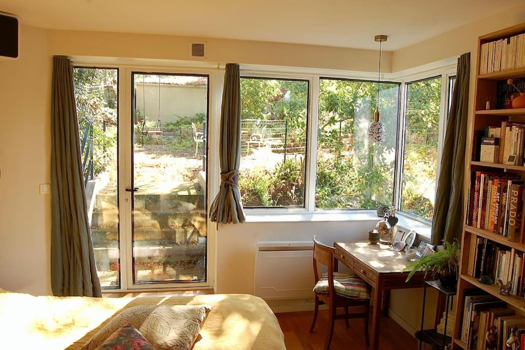 a bedroom with a desk and a window with a table at Un jardin en ville in Nantes