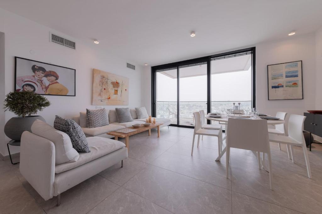 Neve Tzedek Apartment-Hosted by Sweetstay في تل أبيب: غرفة معيشة مع أريكة وطاولة