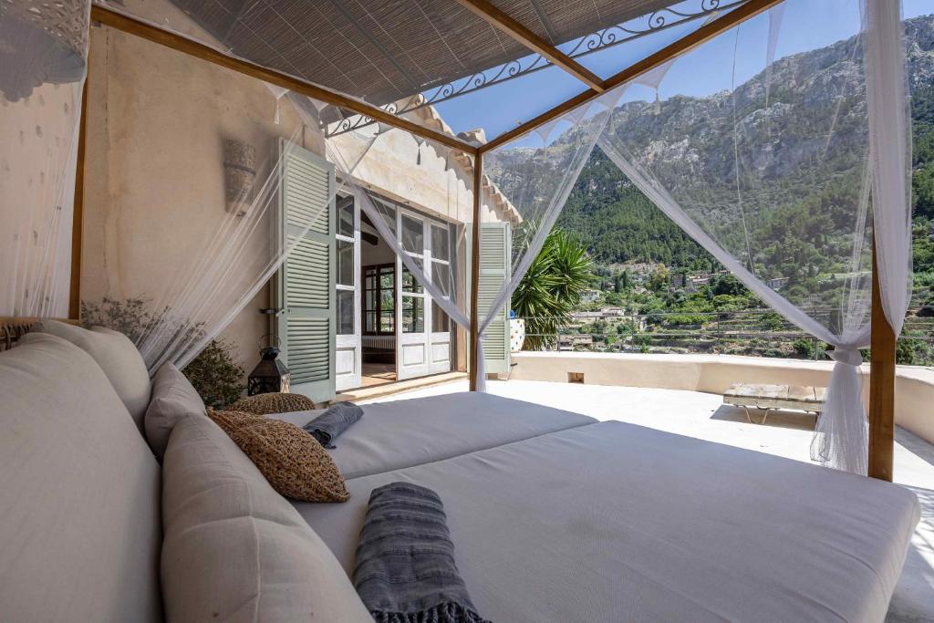 a bedroom with a bed and a view of the mountains at CA'N LA in Deia