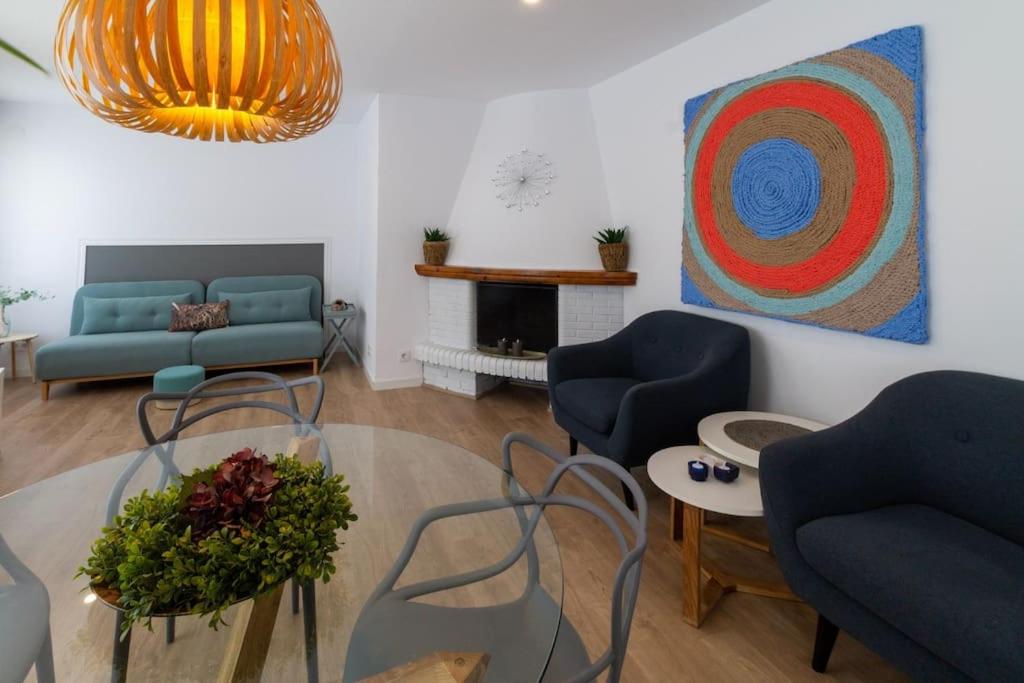 ein Wohnzimmer mit zwei blauen Sofas und einem Gemälde in der Unterkunft Apartament Les Cases in Les Cases d'Alcanar