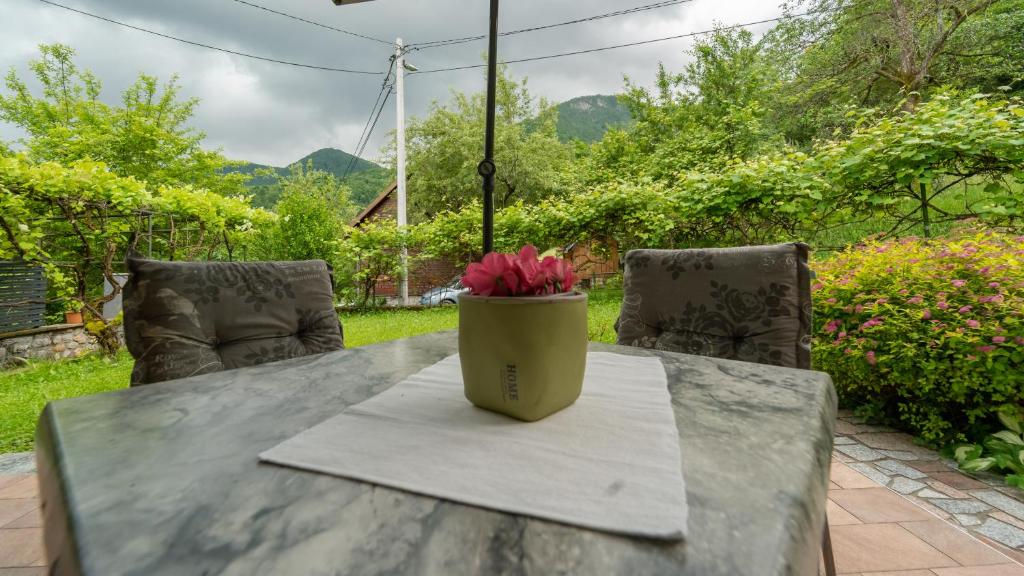 a vase with a pink flower sitting on a table at Holiday house Kajfes in Brod na Kupi