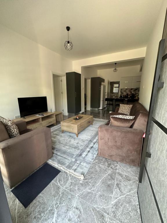 a living room with two couches and a flat screen tv at Ozbilge Apartments in Kyrenia